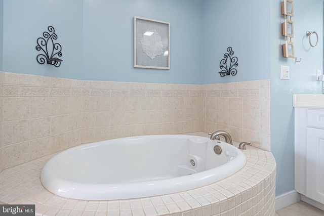 bathroom with vanity and tiled bath