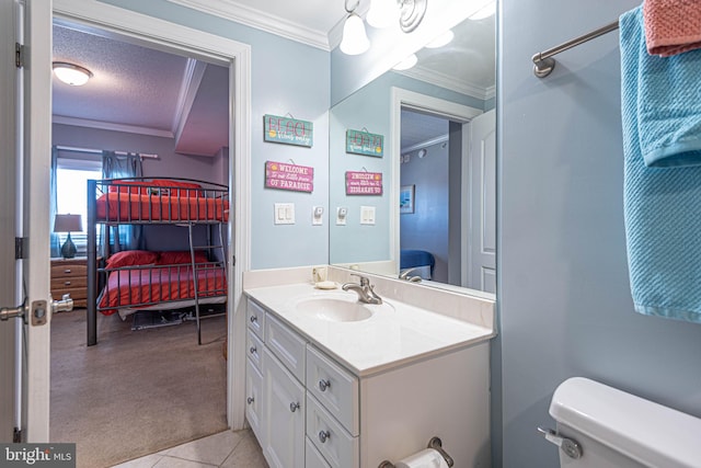 bathroom featuring a textured ceiling, toilet, ornamental molding, vanity, and tile patterned flooring