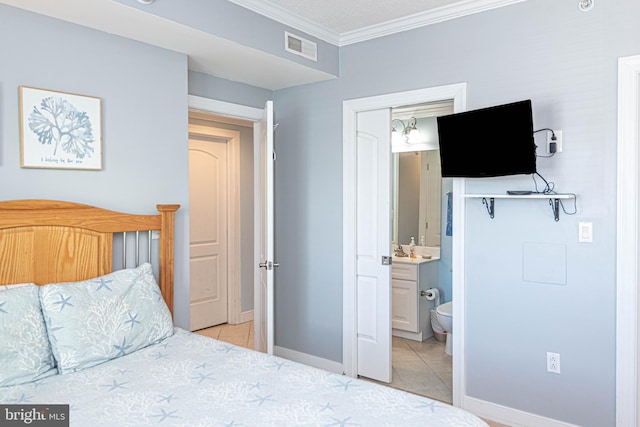 tiled bedroom featuring ornamental molding, sink, and ensuite bathroom