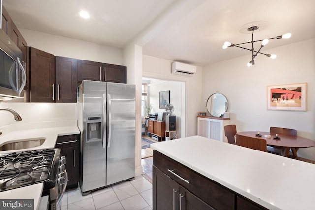 kitchen featuring a wall mounted air conditioner, stainless steel appliances, sink, a notable chandelier, and decorative light fixtures