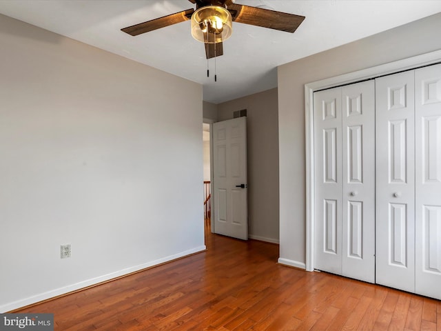 unfurnished bedroom featuring ceiling fan, light hardwood / wood-style floors, and a closet