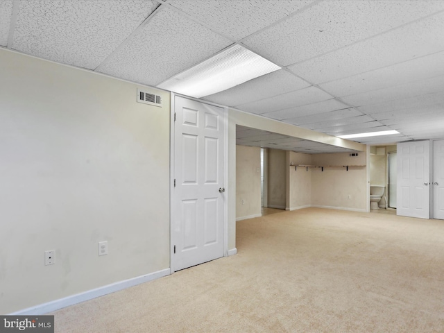 basement featuring carpet floors and a drop ceiling