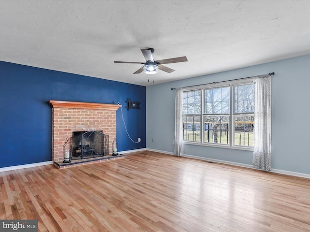 unfurnished living room with light hardwood / wood-style flooring, a fireplace, and a textured ceiling