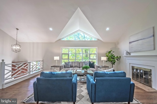 living room featuring hardwood / wood-style floors, a notable chandelier, and high vaulted ceiling