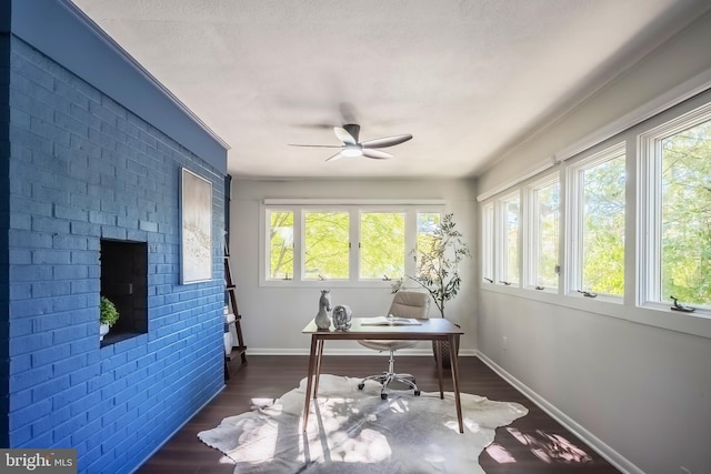 office space featuring a textured ceiling, ceiling fan, brick wall, and dark hardwood / wood-style flooring