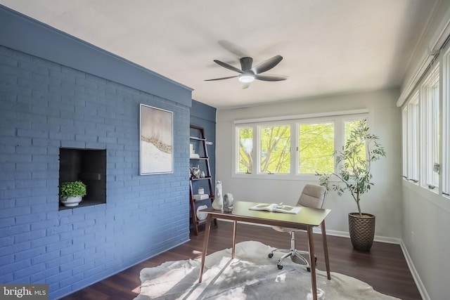 office with brick wall, dark wood-type flooring, and ceiling fan