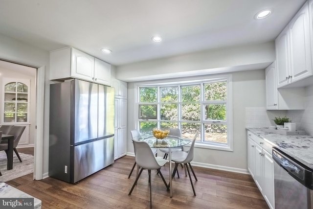 dining room featuring a healthy amount of sunlight and dark hardwood / wood-style flooring