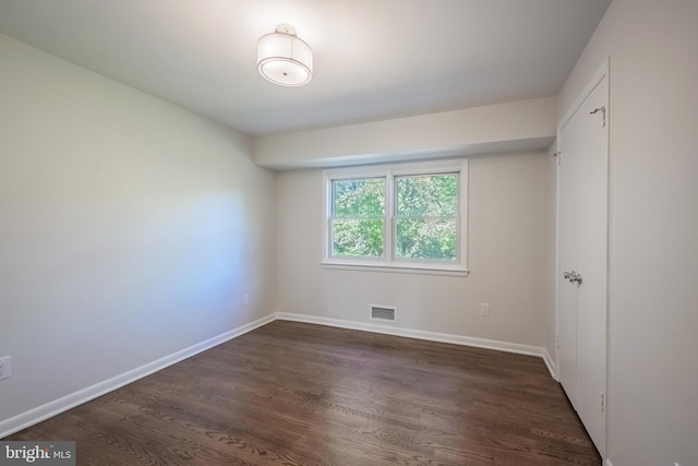 spare room featuring dark wood-type flooring