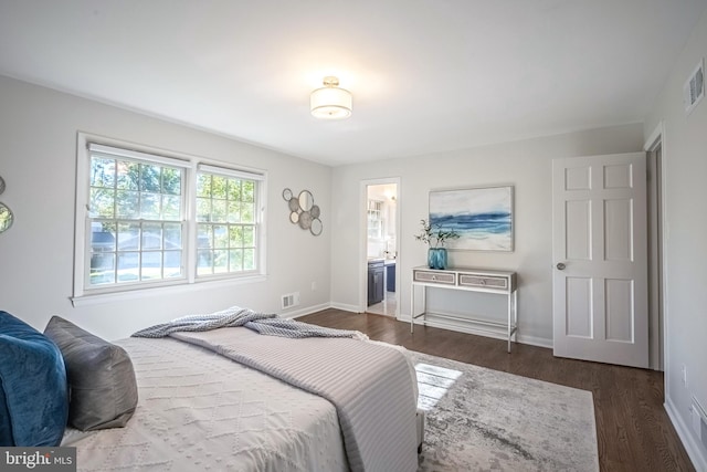 bedroom with dark hardwood / wood-style floors and connected bathroom