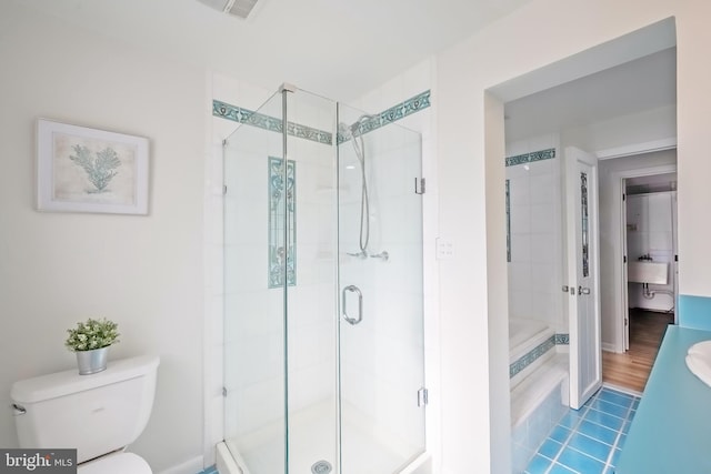 bathroom with a shower with door, toilet, and hardwood / wood-style floors