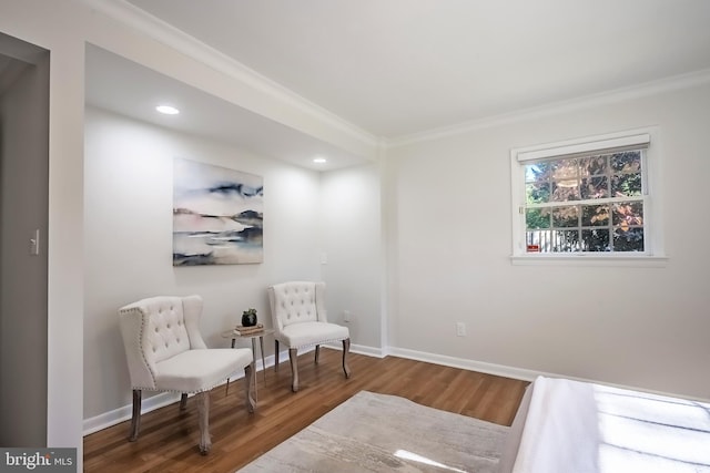 sitting room with crown molding and wood-type flooring