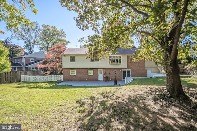 rear view of property featuring a patio area and a lawn