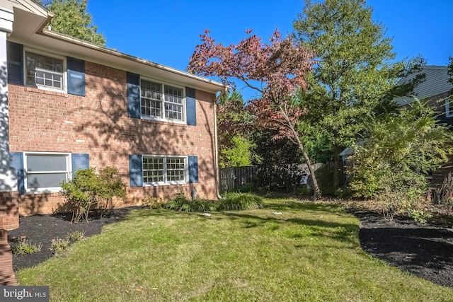 view of side of home with a yard