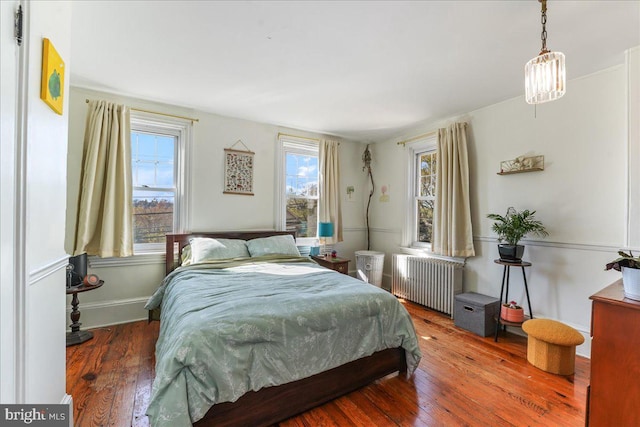 bedroom with hardwood / wood-style flooring and radiator