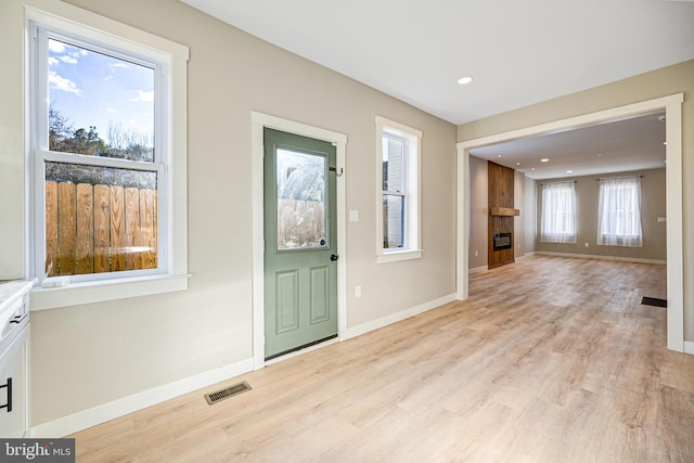 entryway featuring a fireplace and light hardwood / wood-style floors