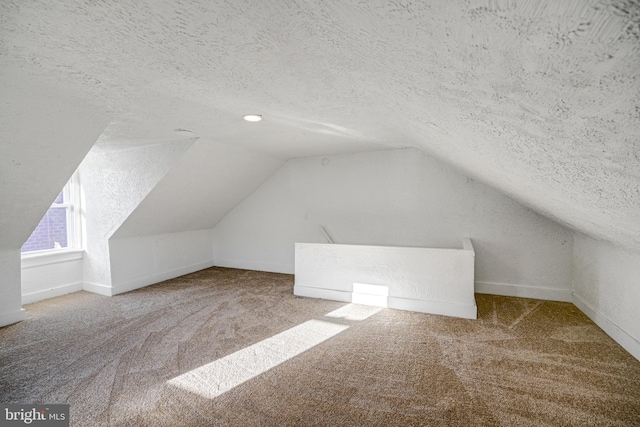 bonus room featuring a textured ceiling, carpet floors, and vaulted ceiling