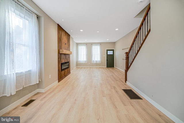 unfurnished living room with light hardwood / wood-style flooring and a large fireplace