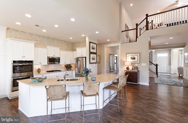 kitchen featuring a spacious island, appliances with stainless steel finishes, a kitchen breakfast bar, and white cabinets