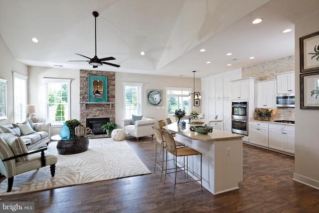 kitchen with white cabinetry, plenty of natural light, a kitchen island, and a kitchen breakfast bar