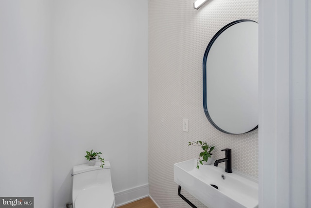 bathroom featuring toilet, sink, and hardwood / wood-style floors