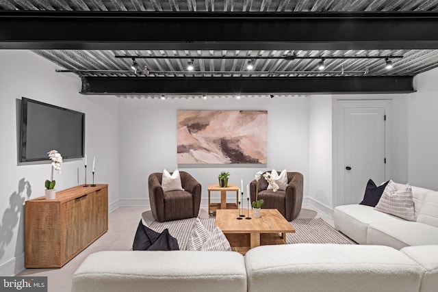 living room with beam ceiling and track lighting