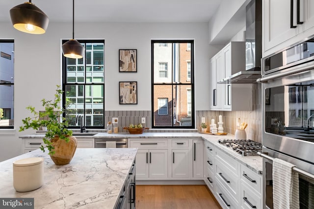 kitchen featuring white cabinets, stainless steel appliances, and plenty of natural light