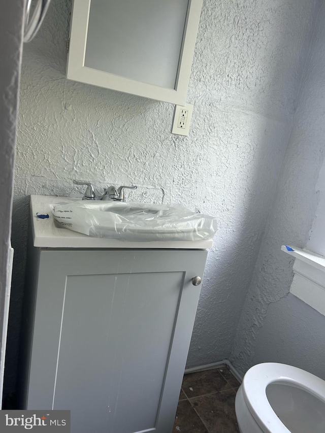 bathroom featuring vanity, toilet, and tile patterned flooring