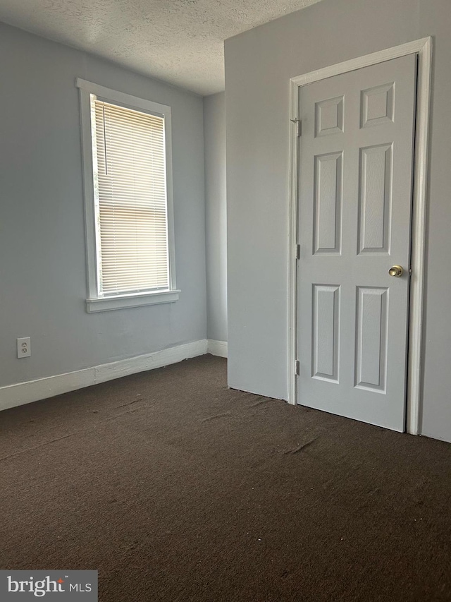 carpeted spare room with a textured ceiling