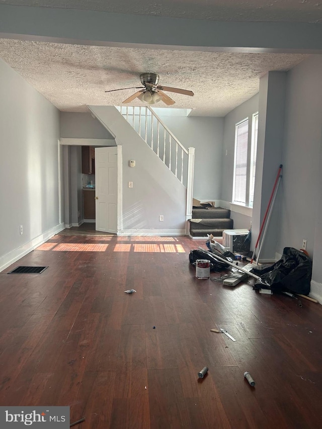 unfurnished living room with ceiling fan, a textured ceiling, and hardwood / wood-style floors