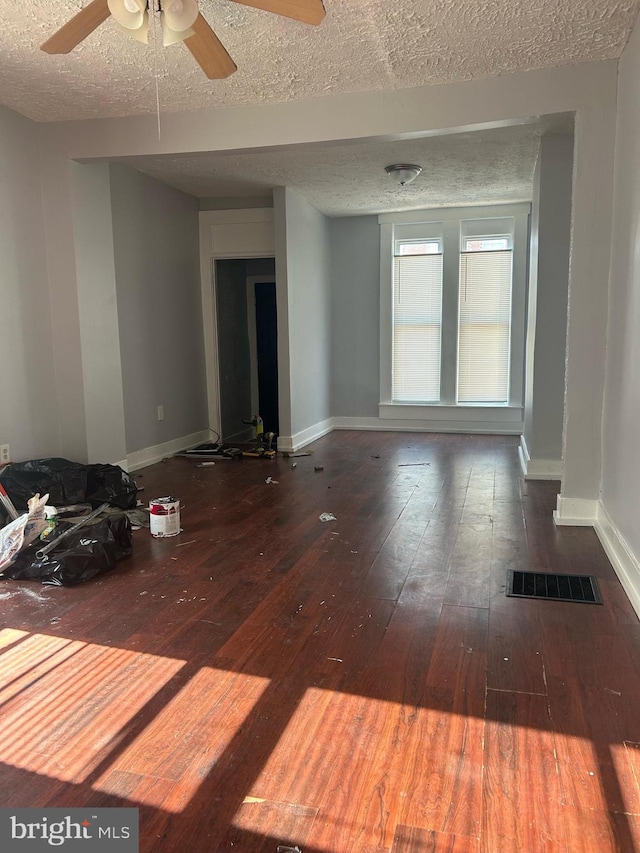 unfurnished room featuring ceiling fan, a textured ceiling, and dark hardwood / wood-style flooring