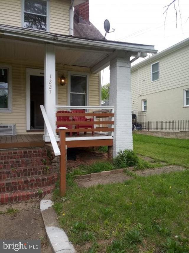 property entrance with a yard and covered porch