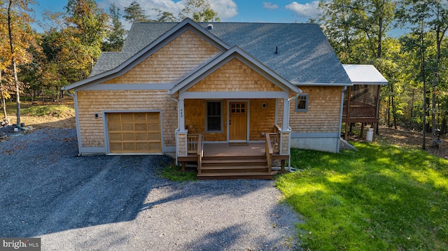 view of front of home with a front lawn, covered porch, and a garage