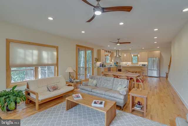 living room featuring light wood-type flooring and ceiling fan