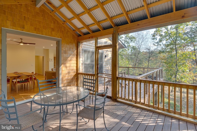 sunroom featuring vaulted ceiling with beams and ceiling fan