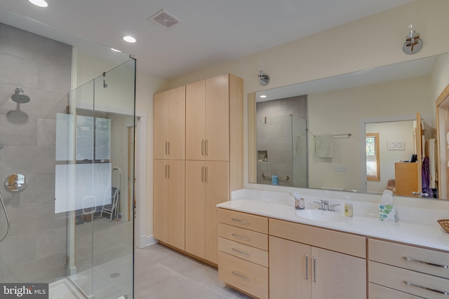 bathroom featuring vanity, a shower with shower door, and tile patterned floors