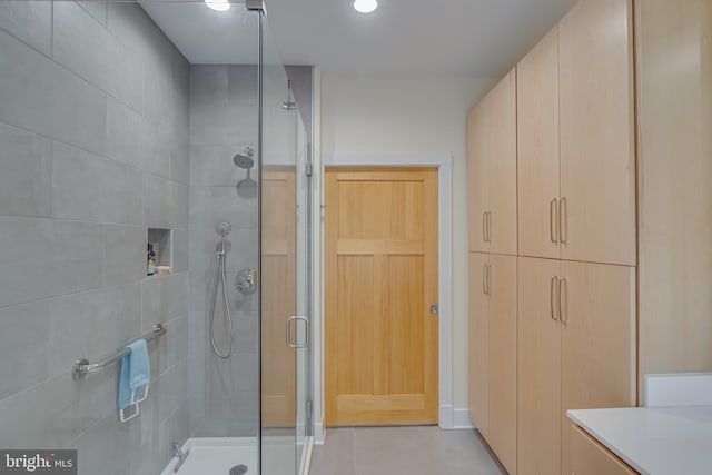 bathroom with vanity, walk in shower, and tile patterned flooring