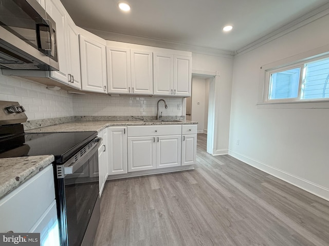 kitchen with white cabinets, stainless steel appliances, light hardwood / wood-style flooring, and sink