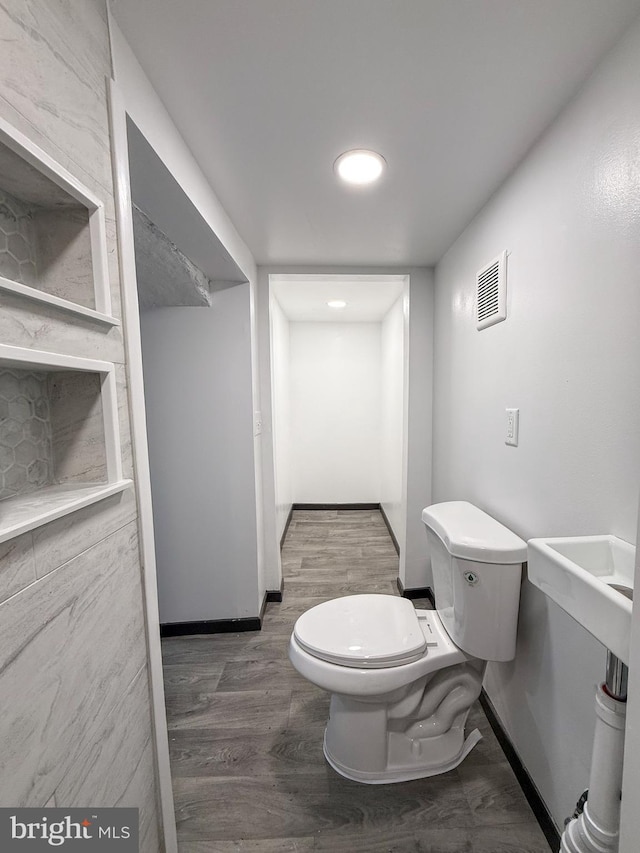 bathroom with hardwood / wood-style floors and toilet