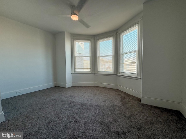 carpeted empty room featuring ceiling fan and a wealth of natural light