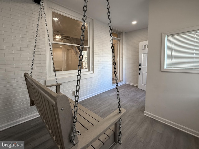 interior space with dark wood-type flooring and brick wall