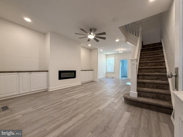 unfurnished living room featuring light wood-type flooring and ceiling fan