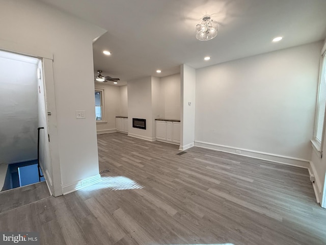 unfurnished living room with hardwood / wood-style floors and ceiling fan