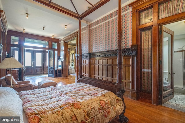 bedroom with french doors, wood-type flooring, and crown molding