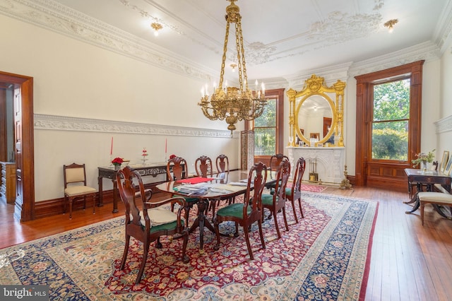 dining space with ornamental molding, a chandelier, and hardwood / wood-style floors