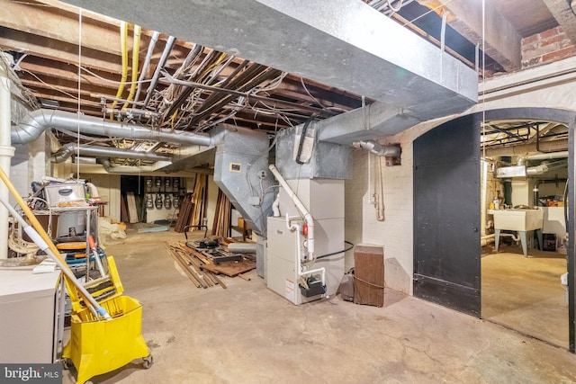 basement featuring heating unit and sink