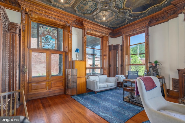 sitting room featuring crown molding, wood-type flooring, and plenty of natural light