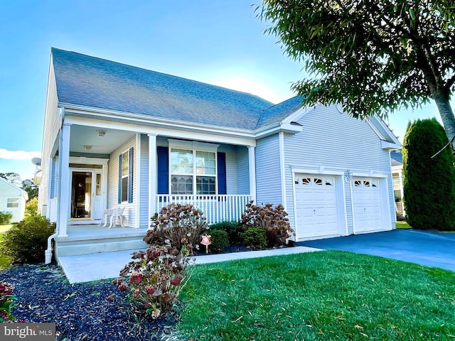 view of front of home with covered porch, a front yard, and a garage