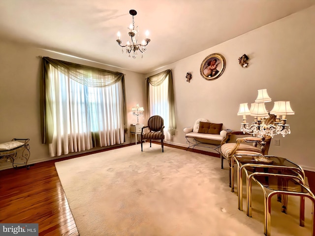 sitting room featuring an inviting chandelier and wood-type flooring