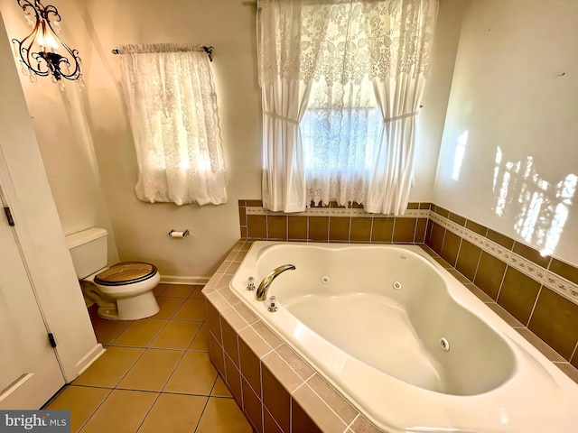 bathroom featuring toilet, a relaxing tiled tub, and tile patterned floors