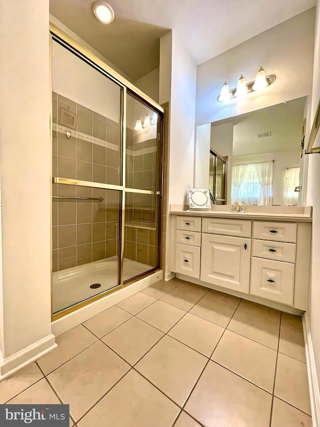 bathroom with vanity, a shower with shower door, and tile patterned flooring